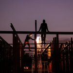 Two construction workers on beams carrying out hot works